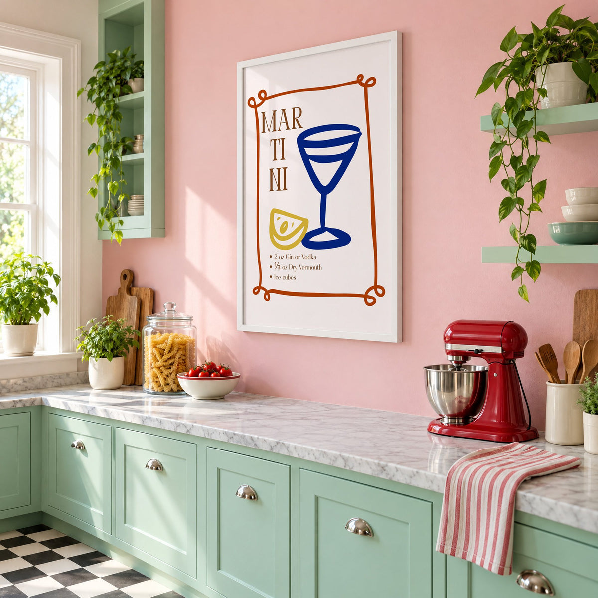 MARTINI recipe navy glass lemon print in a white frame on a pink wall above mint green cabinets in a retro kitchen, seen at an angle