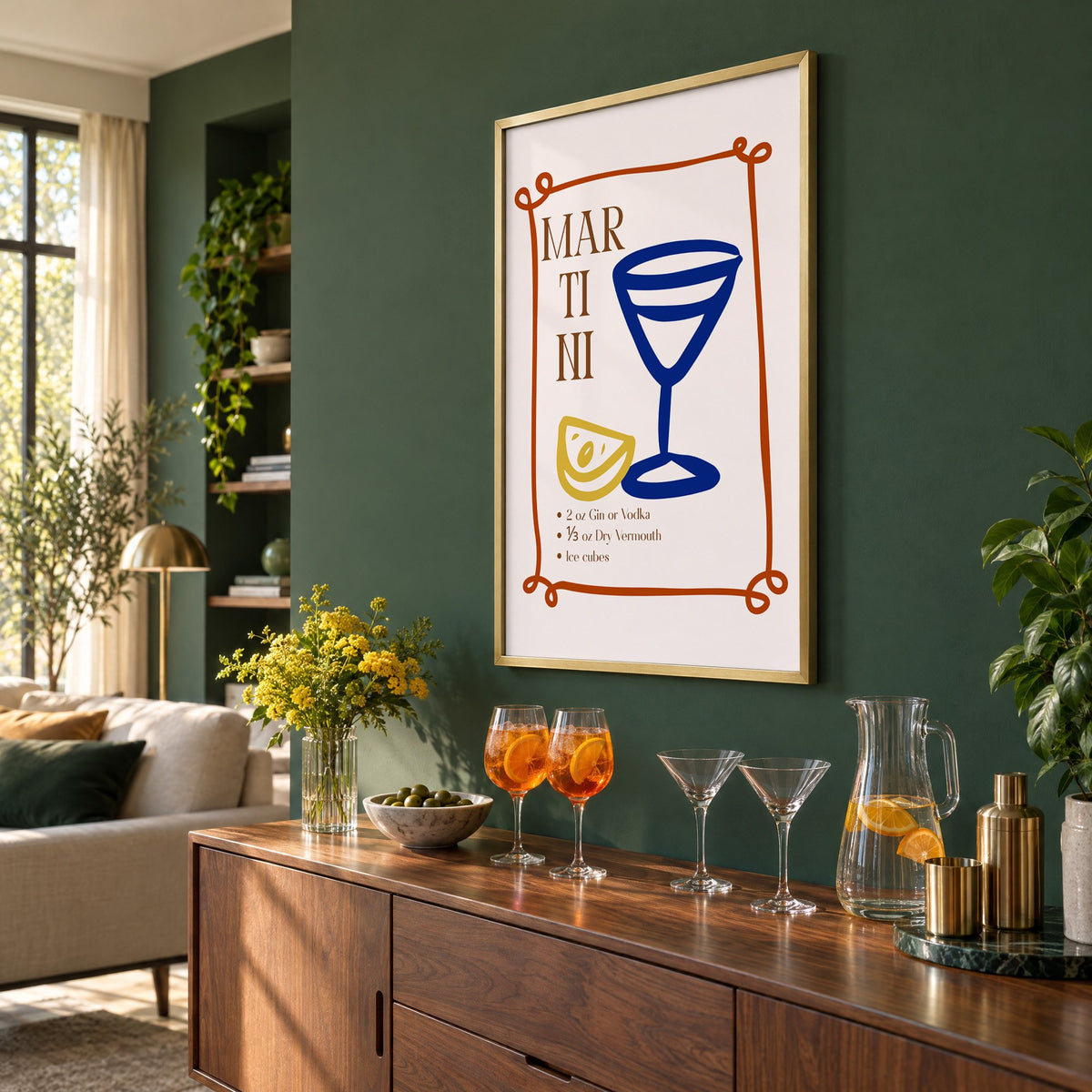 MARTINI recipe navy glass lemon print in a brass frame on a bottle green wall above a sideboard with spritz and martini glasses, seen at an angle
