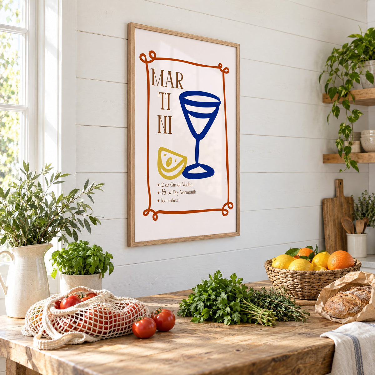 MARTINI recipe navy glass lemon print in an oak frame on a shiplap wall above a farm table with market tomatoes and citrus, seen at an angle