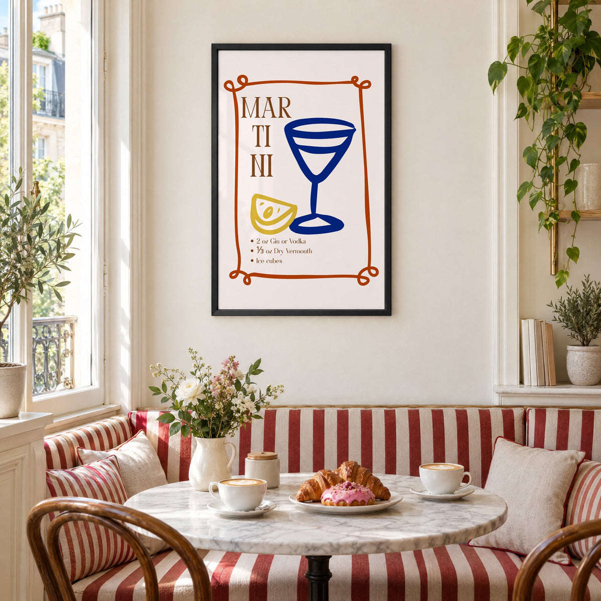 MARTINI recipe navy glass lemon print in a black frame above a striped cafe breakfast nook with cappuccino and pastries