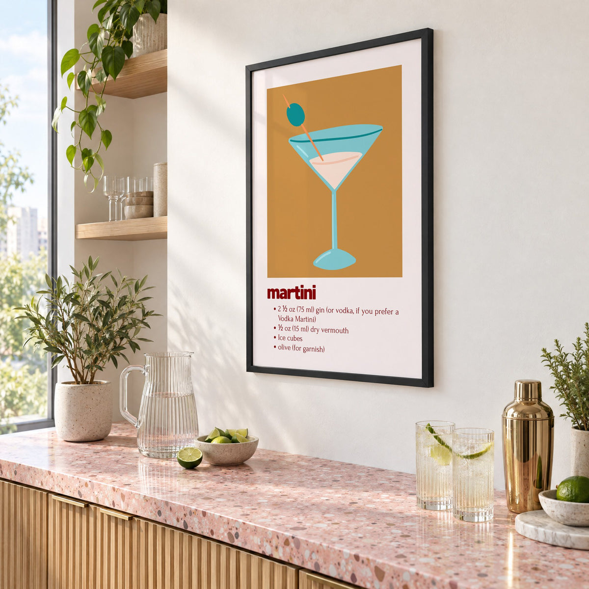 martini recipe olive glass ochre card print in a black frame above a pink terrazzo cocktail counter with limes, seen at an angle