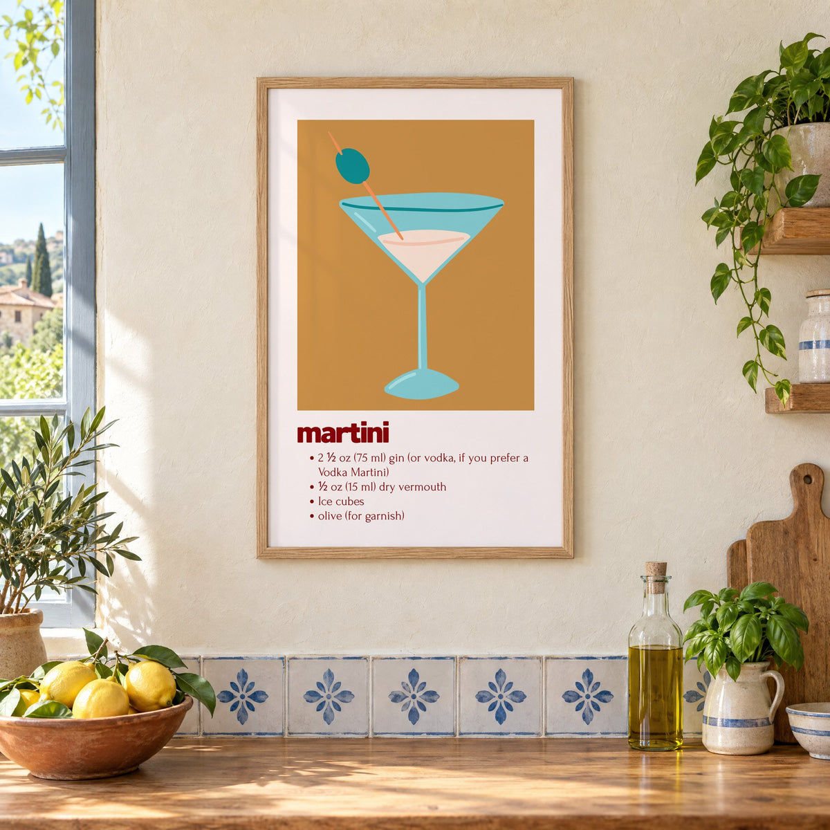 martini recipe olive glass ochre card print in an oak frame on a cream plaster wall above a worktop with a bowl of lemons and blue-and-white tiles