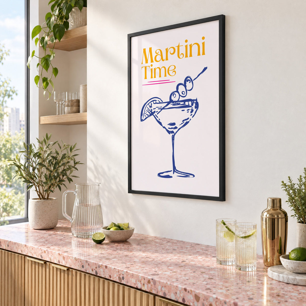 Martini Time blue sketch print in a black frame above a pink terrazzo cocktail counter with limes, seen at an angle