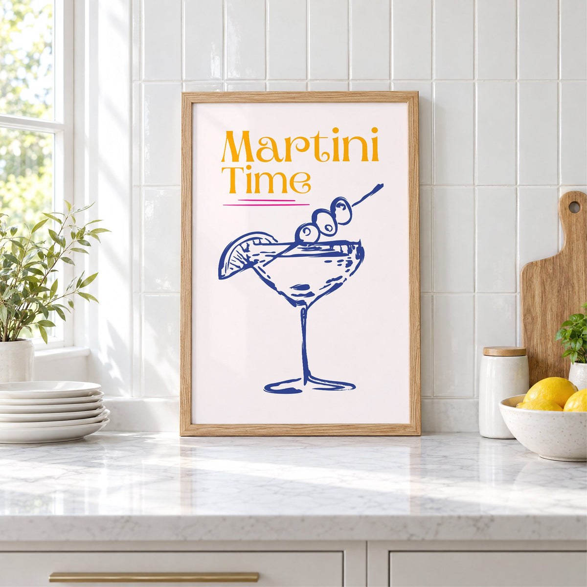 Martini Time blue sketch print in an oak frame leaning on a marble counter by white tiles and lemons