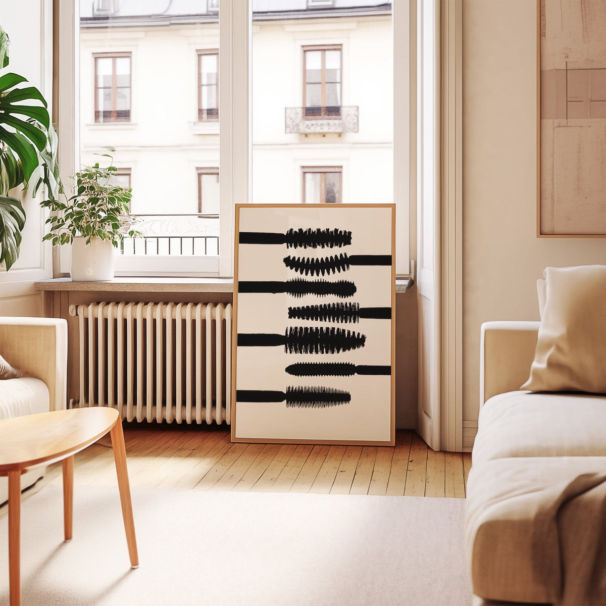 Seven mascara wand silhouettes on white print in an oak frame leaning by a French window in a living room