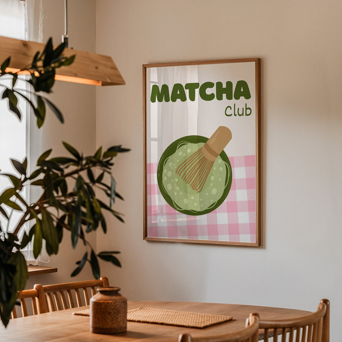 Matcha Club print in a walnut frame above a dining table with olive branches