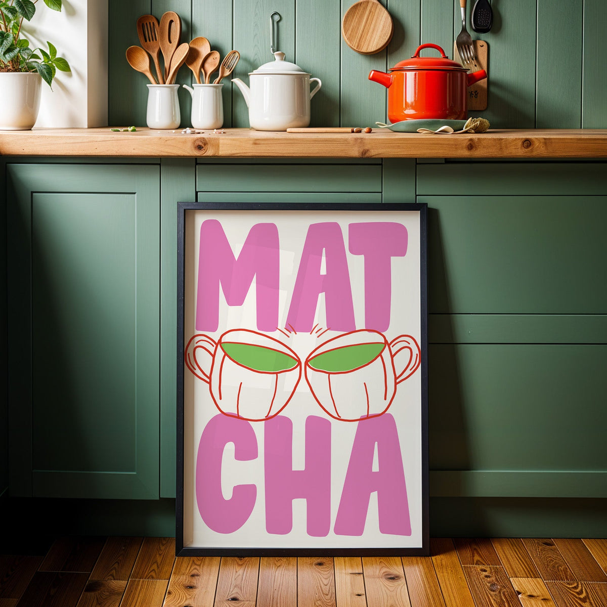 Matcha two cups print in a black frame against sage green kitchen cabinets