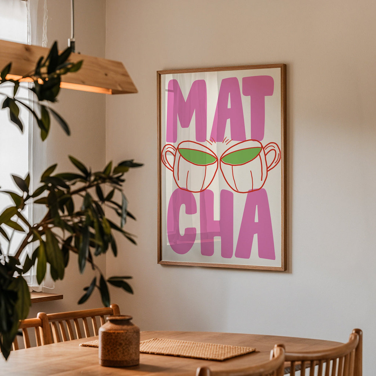 Matcha two cups print in a walnut frame above a dining table beside an olive tree