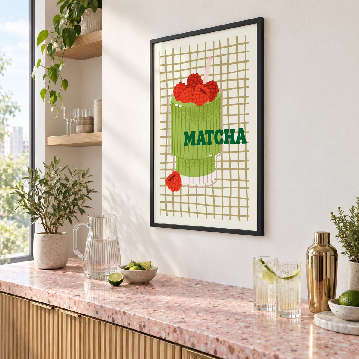 MATCHA raspberry glass on grid print in a black frame above a pink terrazzo cocktail counter with limes, seen at an angle