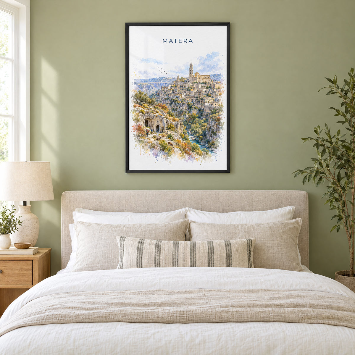 Matera watercolor print in a black frame above an upholstered headboard in a sage green bedroom