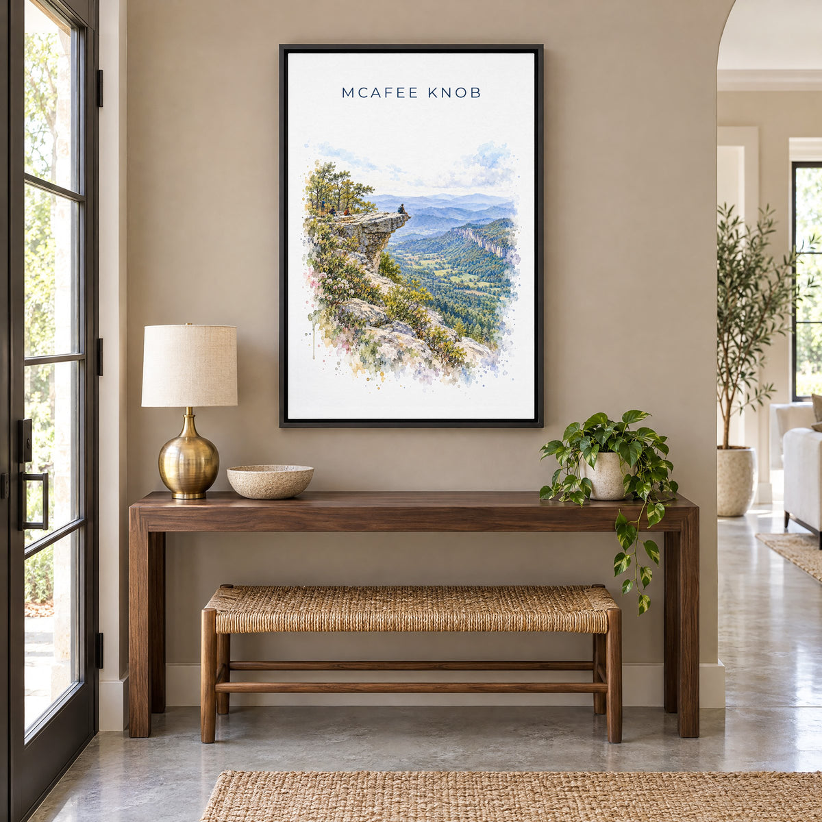 McAfee Knob watercolor print as a black floater canvas above a walnut console and woven bench in an entryway