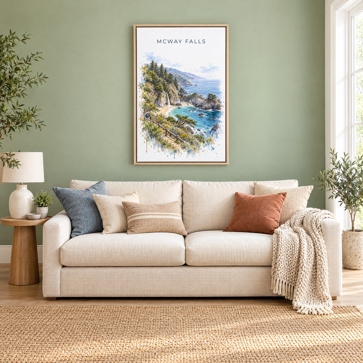 McWay Falls watercolor print as a natural floater canvas above a cream linen sofa on a sage green wall