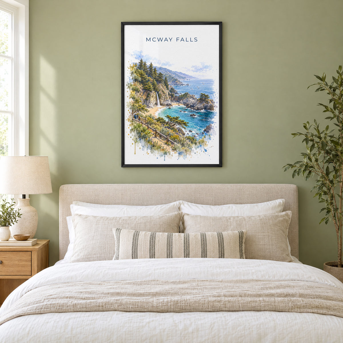 McWay Falls watercolor print in a black frame above an upholstered headboard in a sage green bedroom