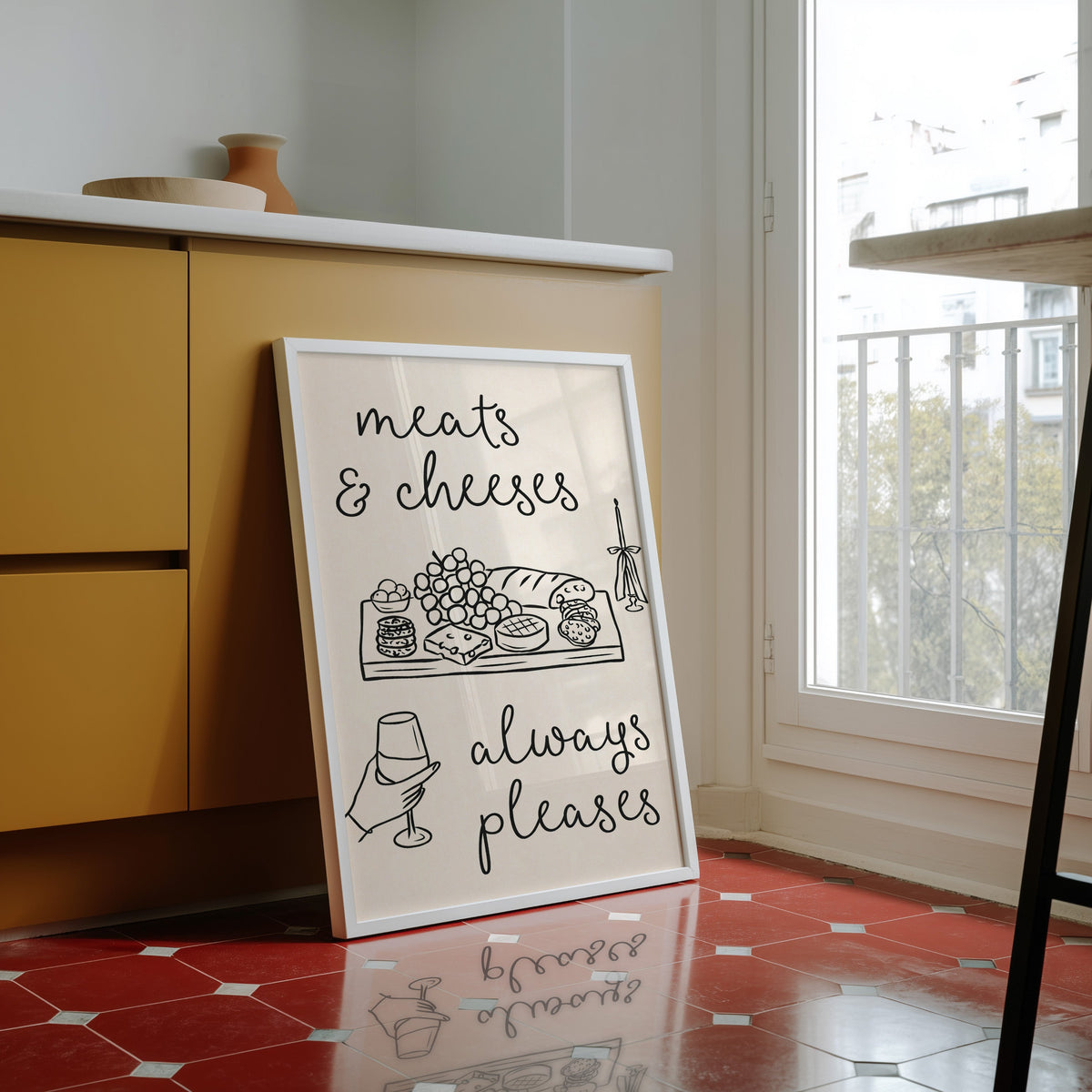 Charcuterie board print in a white frame against yellow cabinets on red tiles