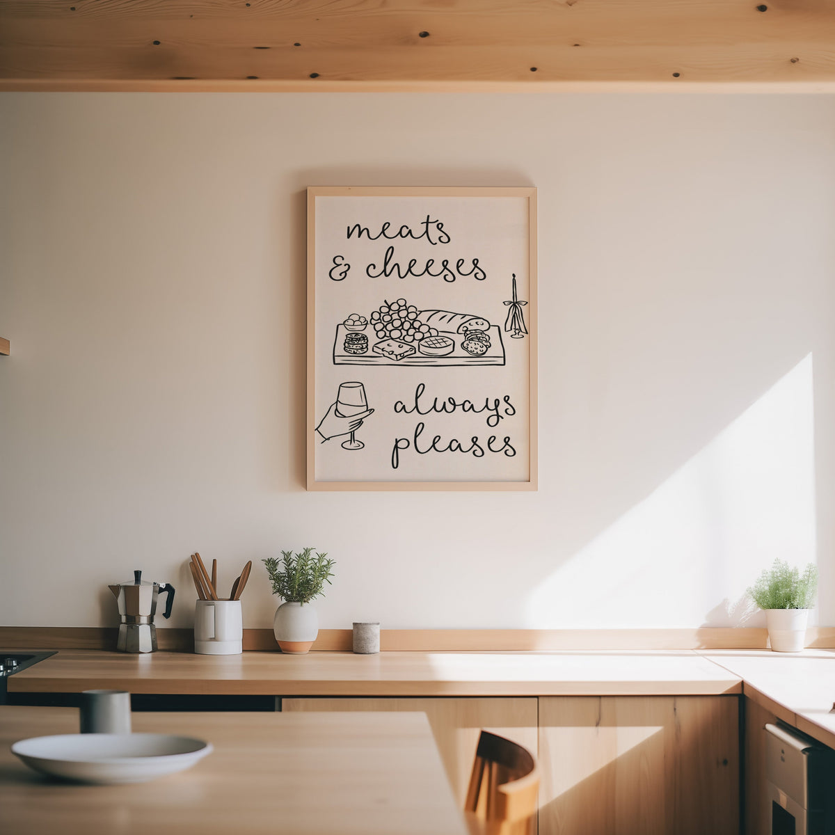 Charcuterie board print in an oak frame above a wood counter with a moka pot