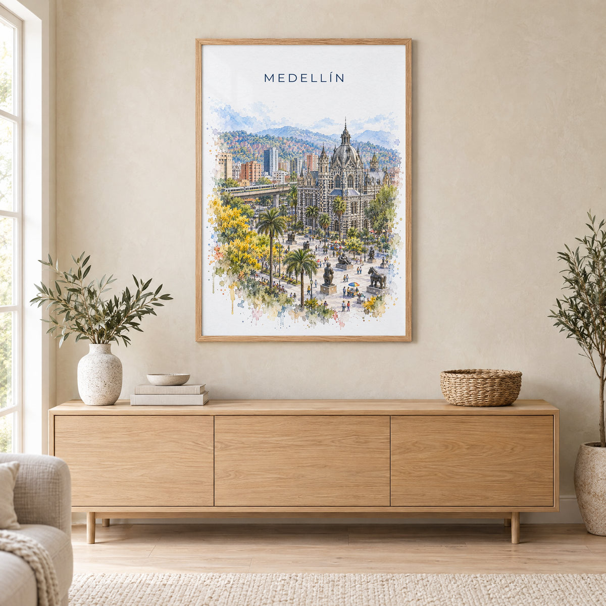 Medellín watercolor print in an oak frame above a light wood sideboard in a Scandinavian living room