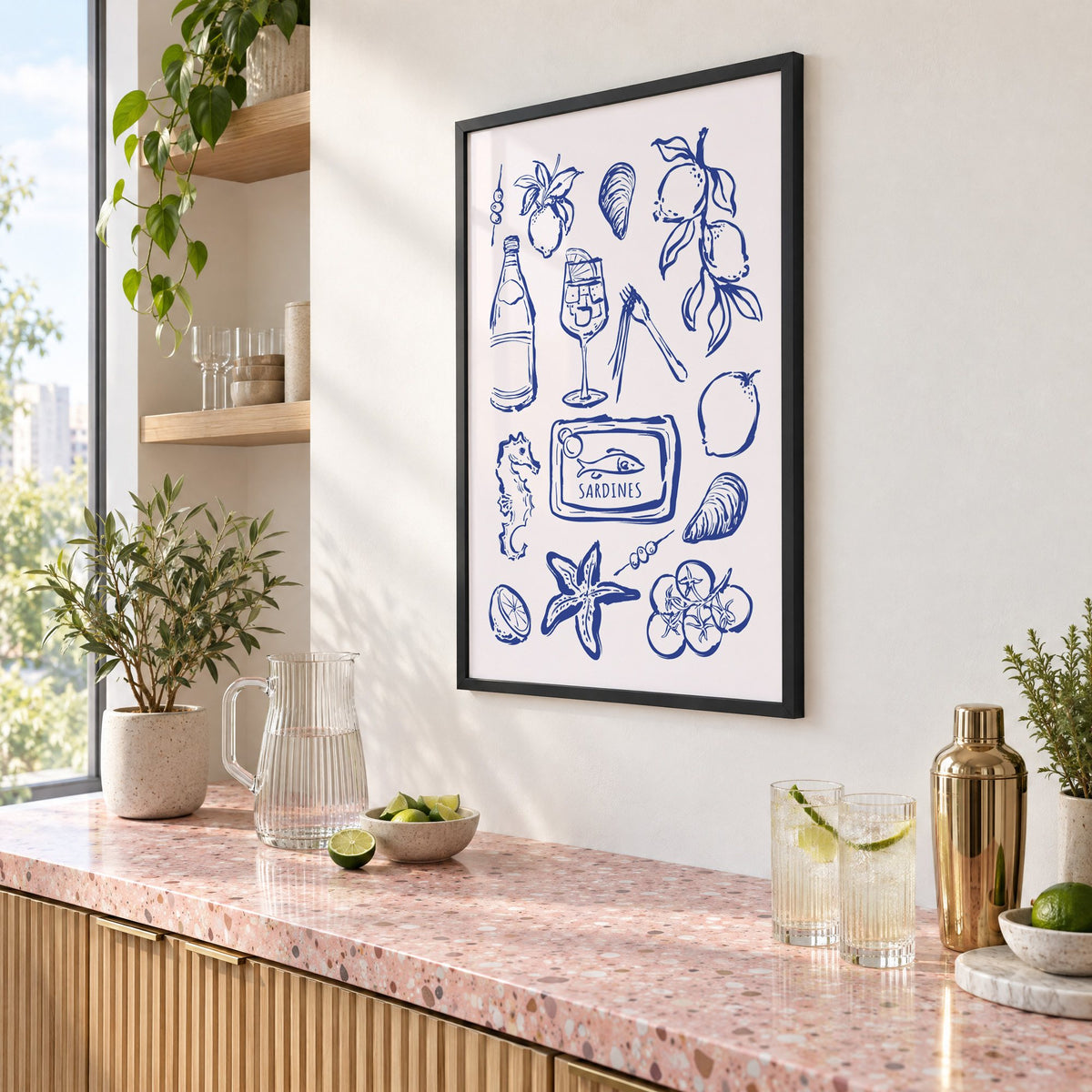 SARDINES tin blue doodle print in a black frame above a pink terrazzo cocktail counter with limes, seen at an angle