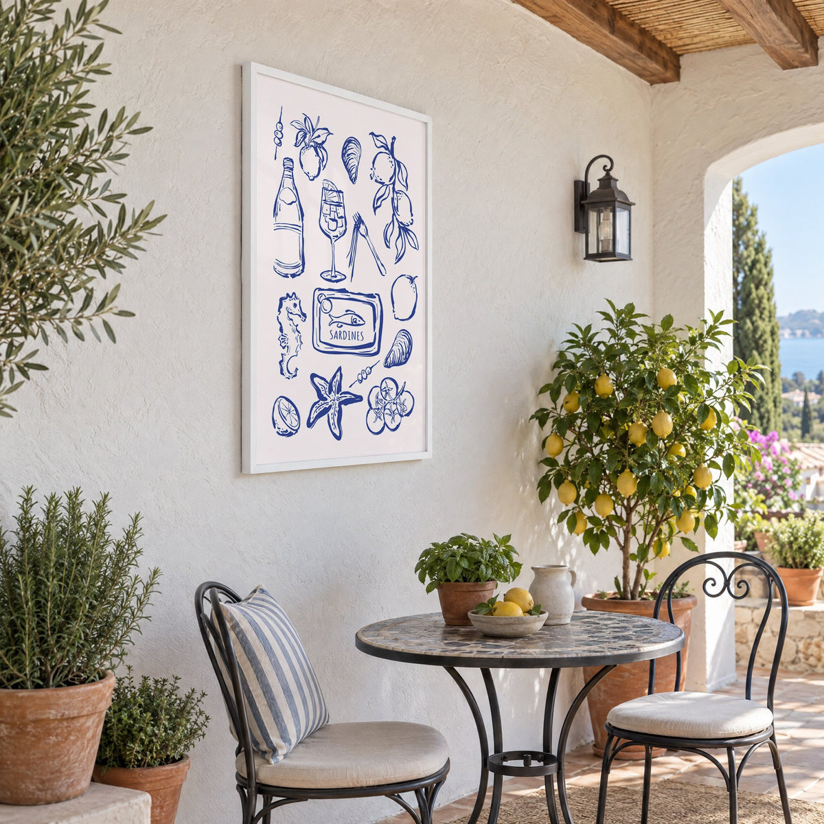 SARDINES tin blue doodle print in a white frame on a sunny patio wall beside a potted lemon tree