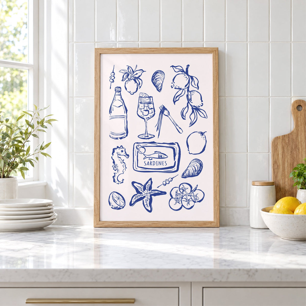 SARDINES tin blue doodle print in an oak frame leaning on a marble counter by white tiles and lemons