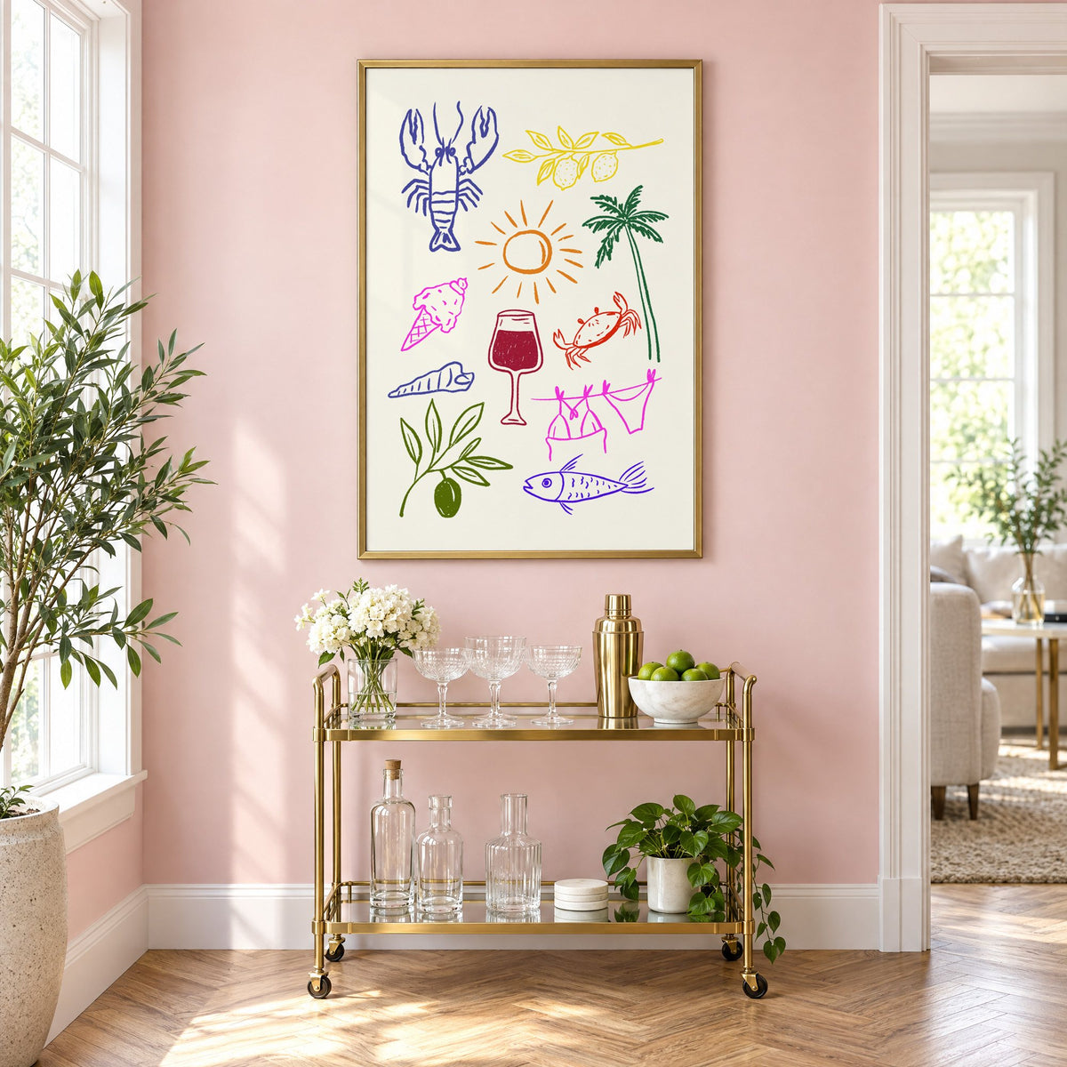 Mediterranean summer doodles lobster and wine print in a brass frame on a blush pink wall above a gold bar cart with glassware