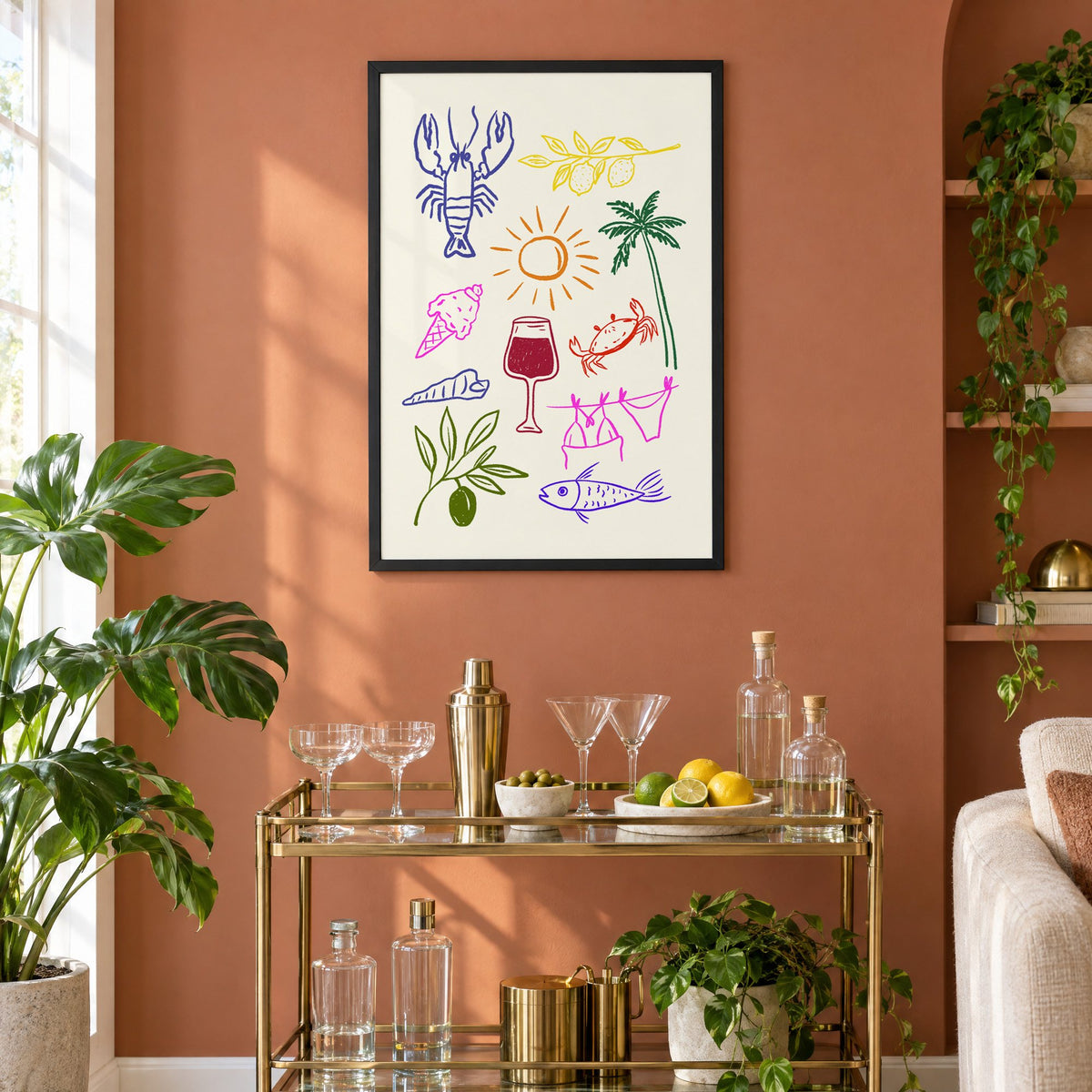 Mediterranean summer doodles lobster and wine print in a black frame on a terracotta wall above a brass bar cart with coupes and citrus