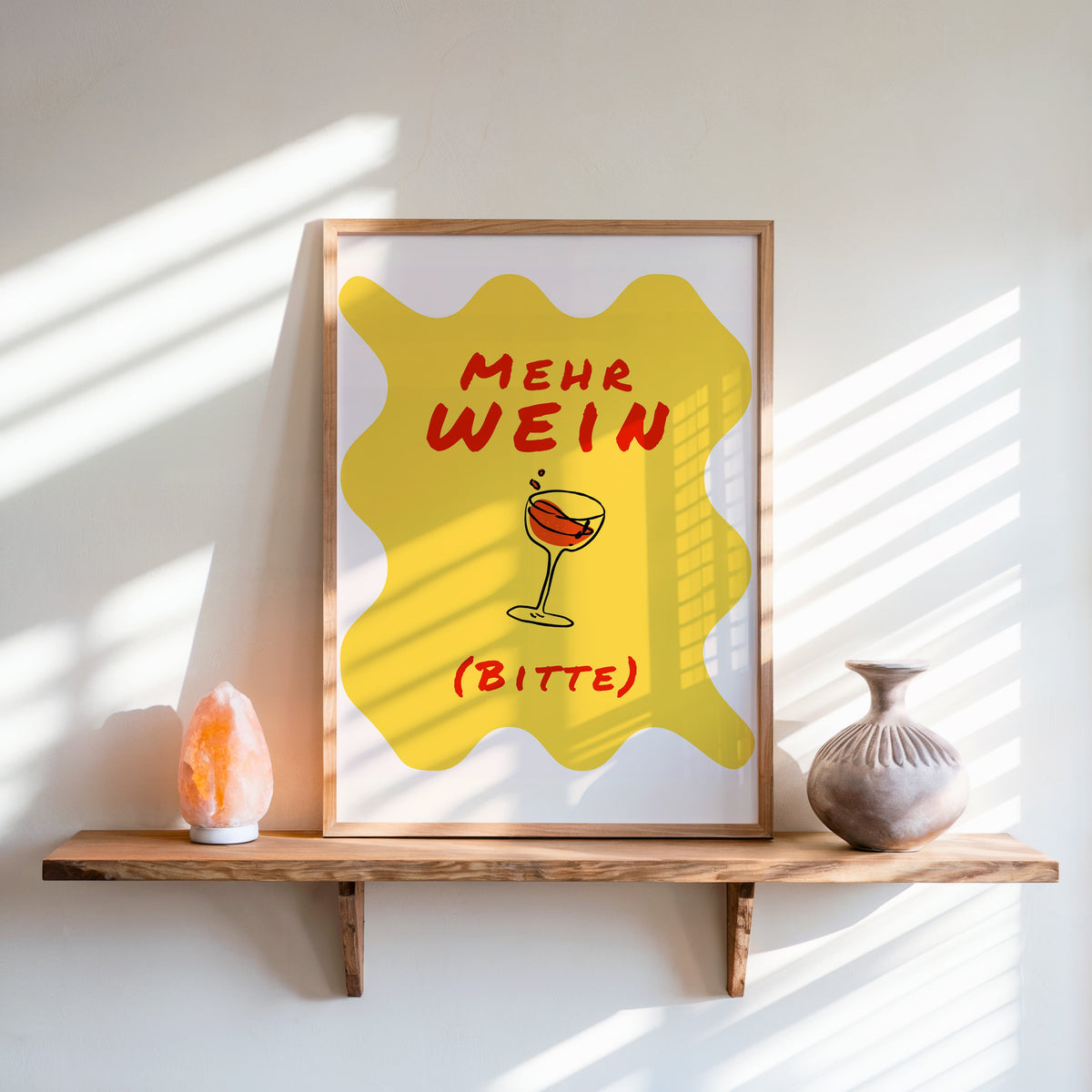 Mehr Wein Bitte print in an oak frame on a live-edge shelf beside a salt lamp