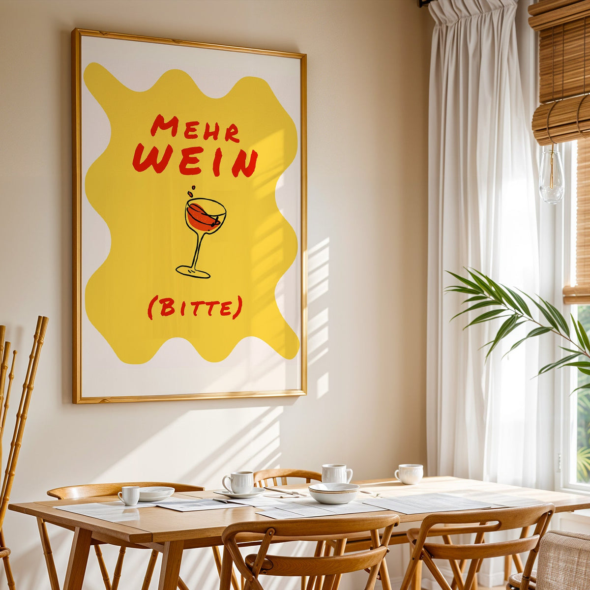Mehr Wein Bitte print shown in a gold frame above a breakfast table by a curtained window
