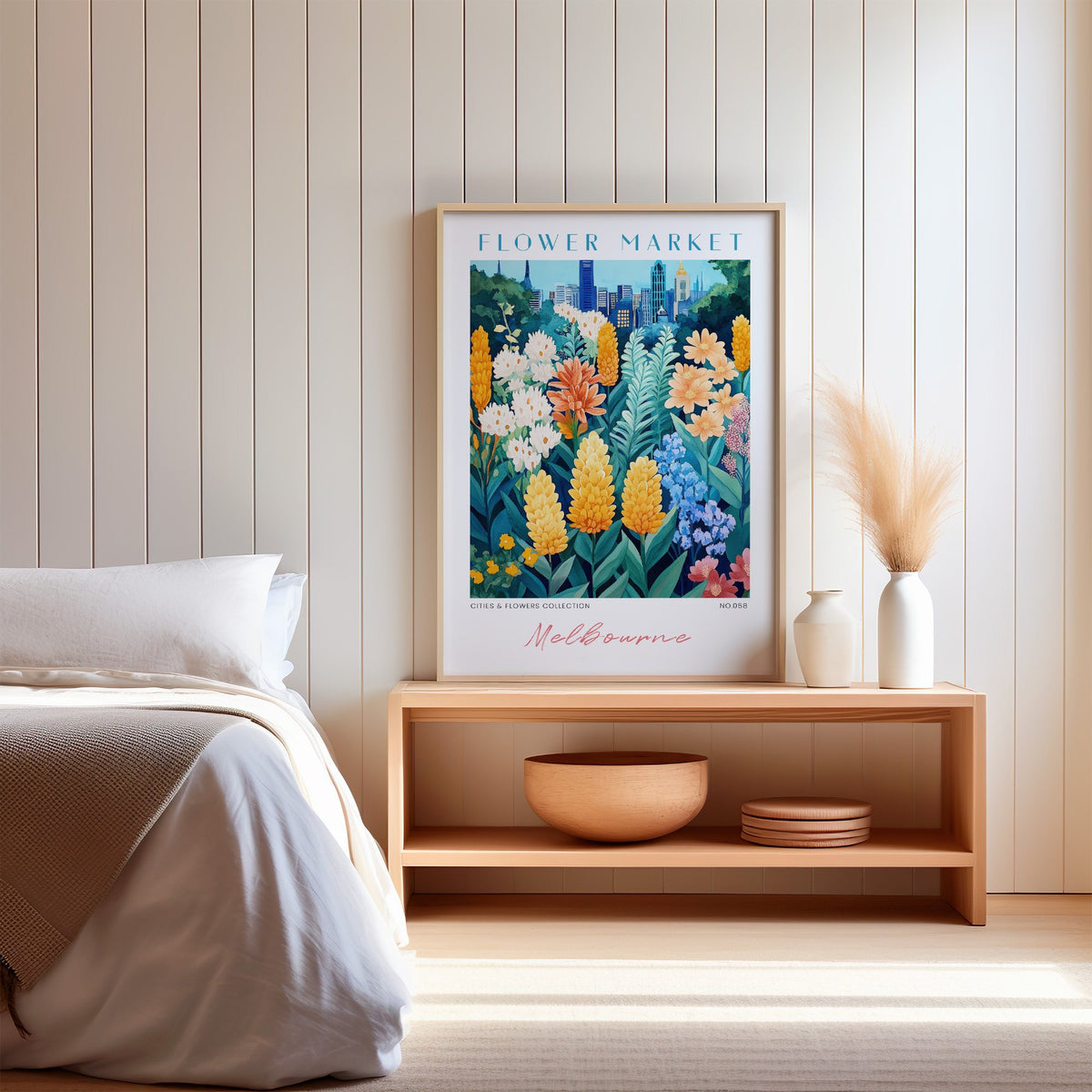 Melbourne flower market print in an oak frame on a wood bench against a white shiplap bedroom wall with pampas grass