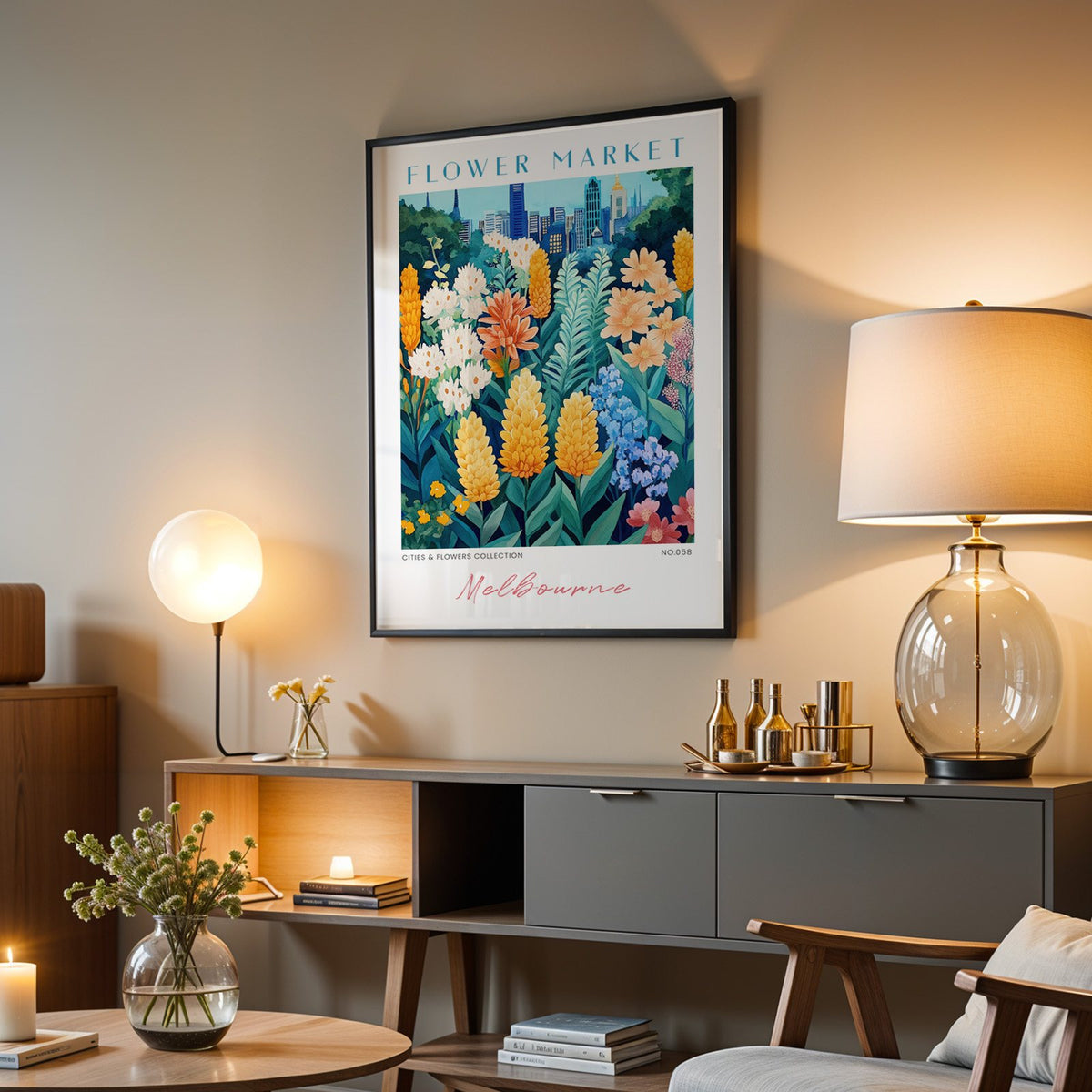 Melbourne flower market print in a black frame above a grey media console with a glass table lamp