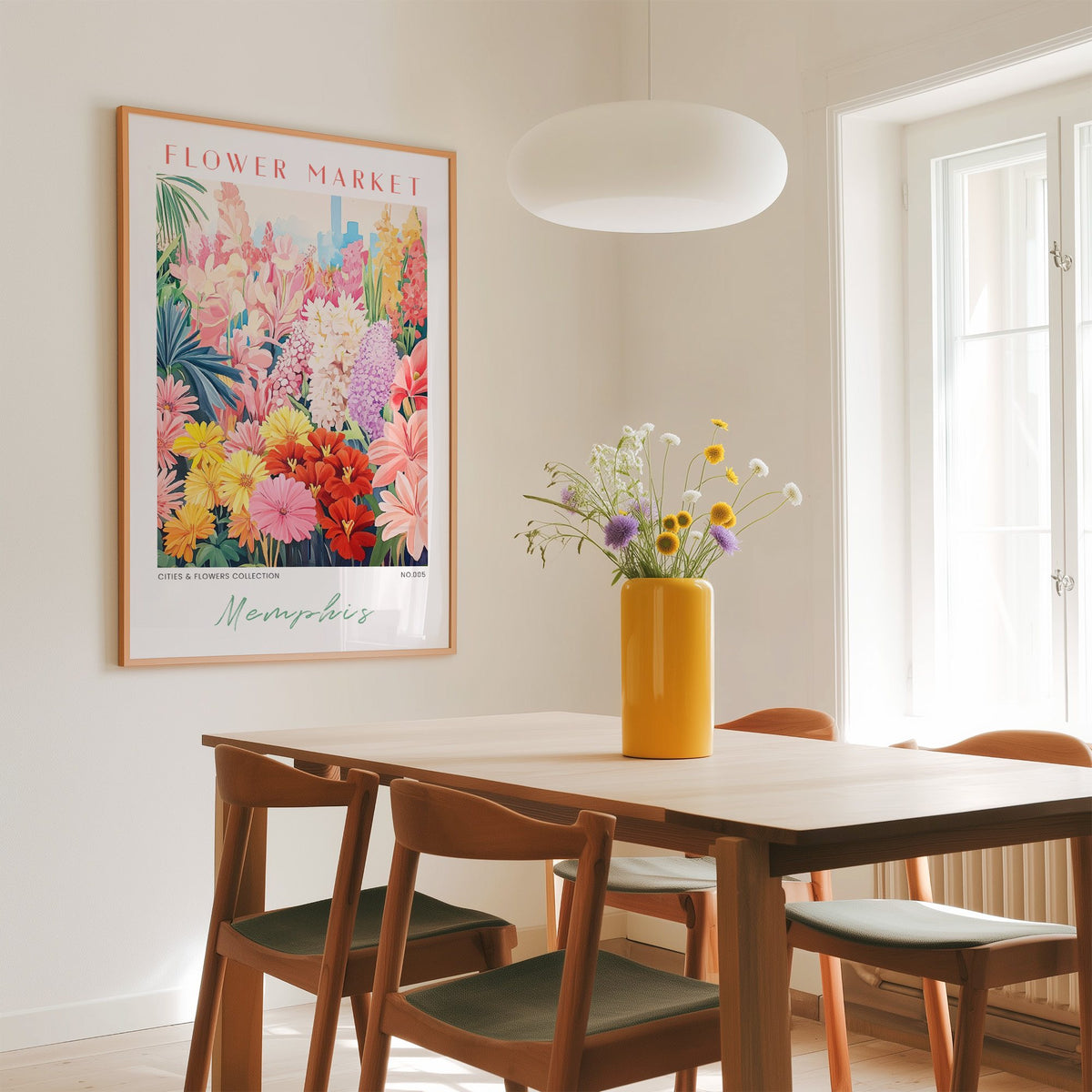 Memphis flower market print in an oak frame above a dining table with a yellow vase and white pendant light