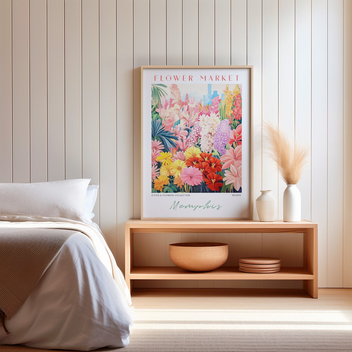 Memphis flower market print in an oak frame on a wood bench against a white shiplap bedroom wall with pampas grass