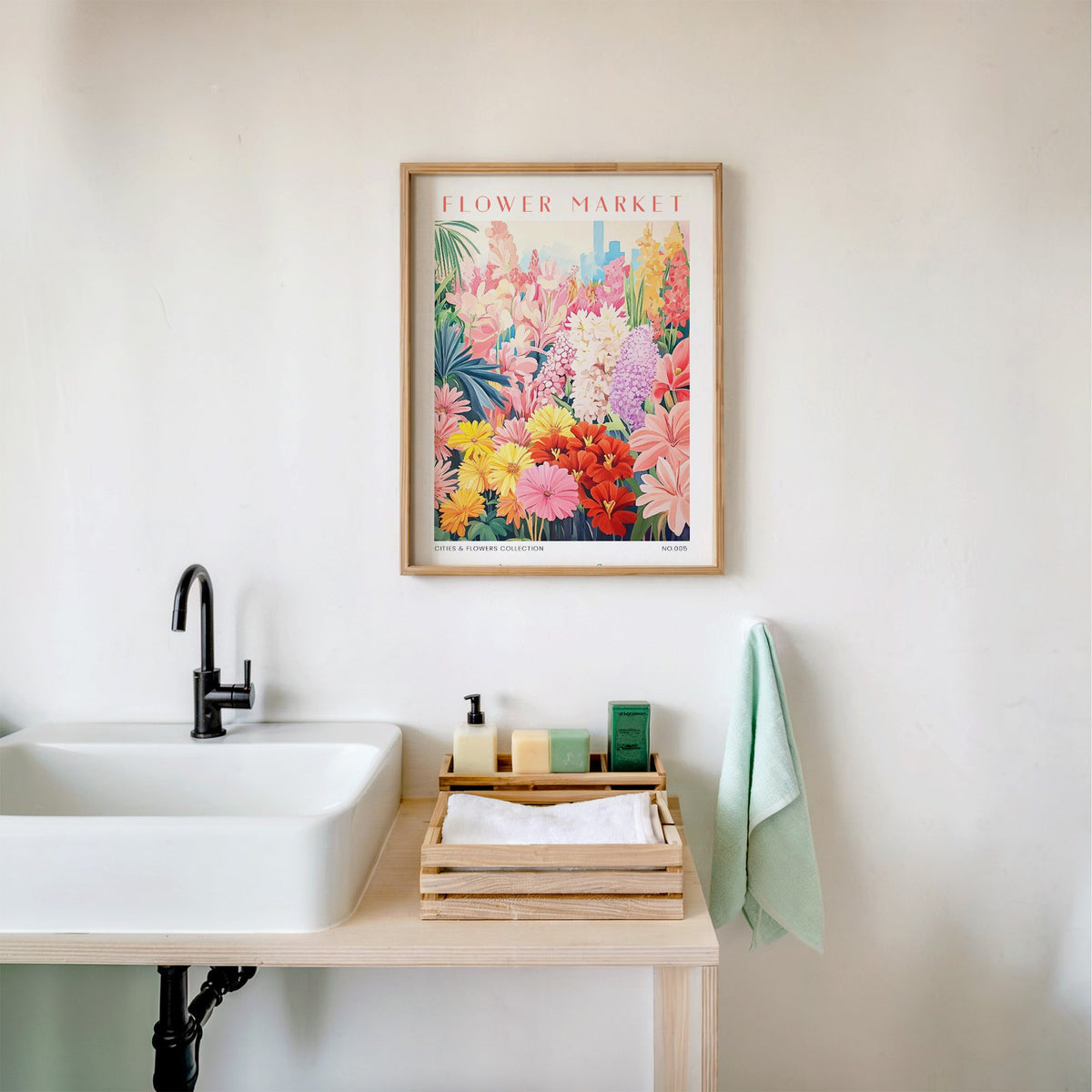 Memphis flower market print in an oak frame above a white bathroom sink with folded towels