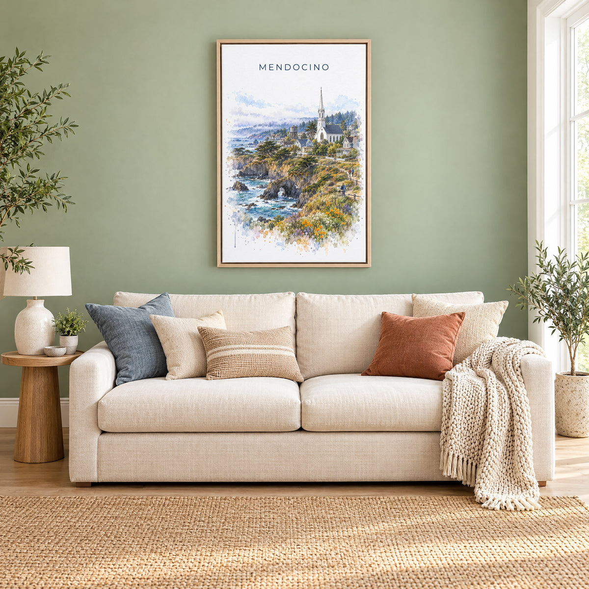 Mendocino watercolor print as a natural floater canvas above a cream linen sofa on a sage green wall