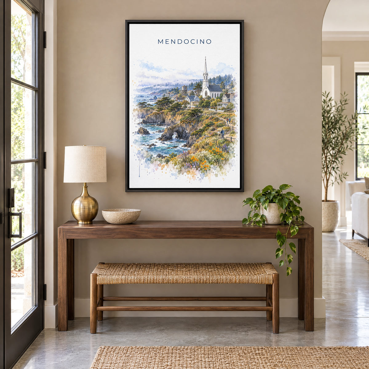 Mendocino watercolor print as a black floater canvas above a walnut console and woven bench in an entryway