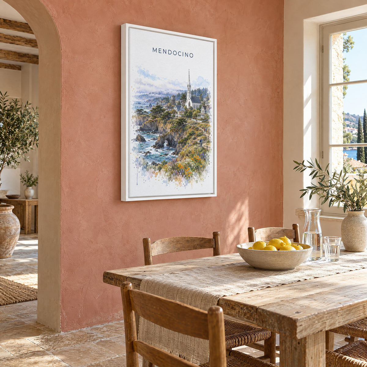 Mendocino watercolor print as a white floater canvas on a terracotta wall above a rustic dining table