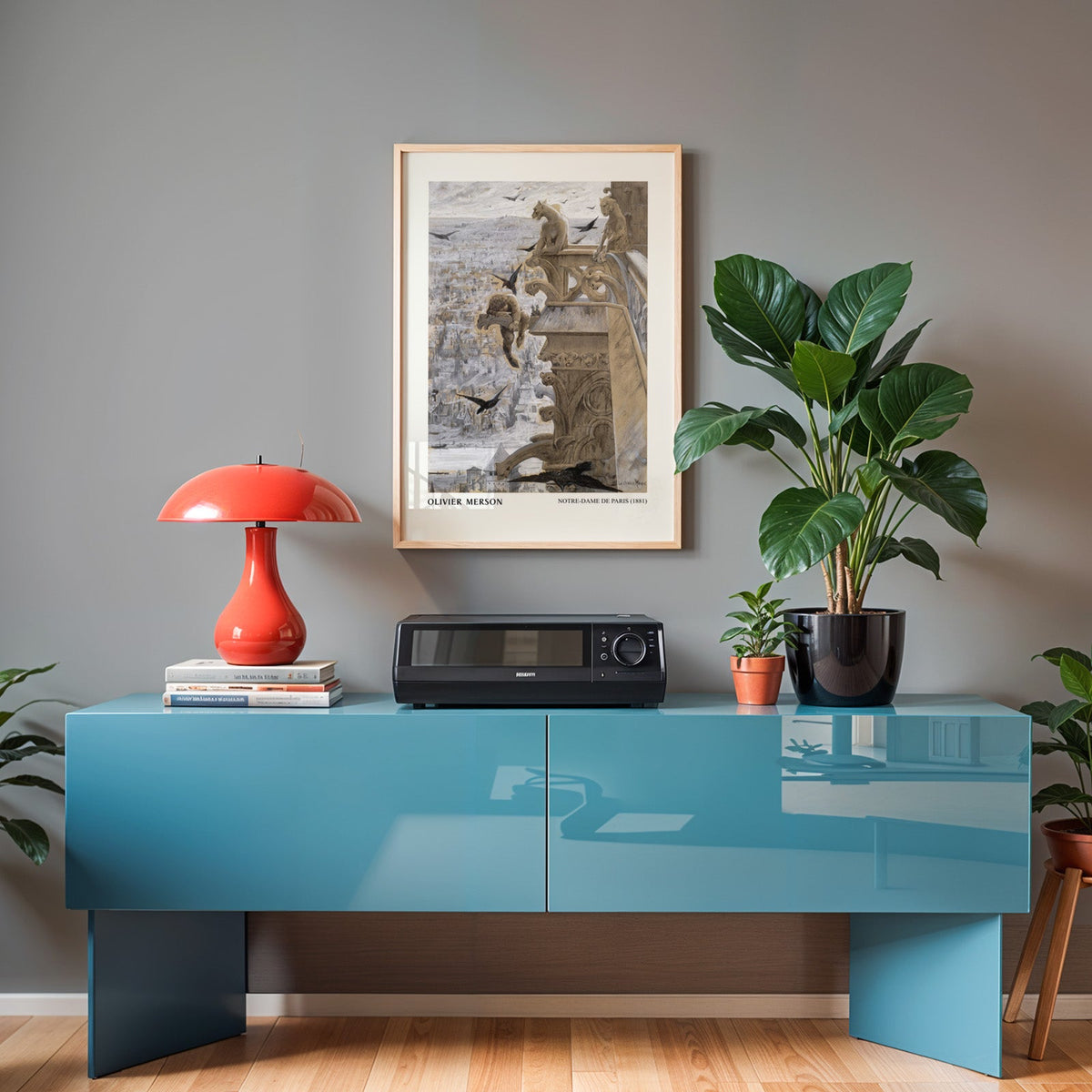 Paris illustration print in an oak frame above a teal sideboard with a red lamp