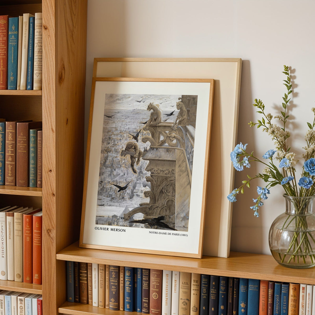Notre-Dame print in an oak frame leaning on a bookshelf beside blue flowers
