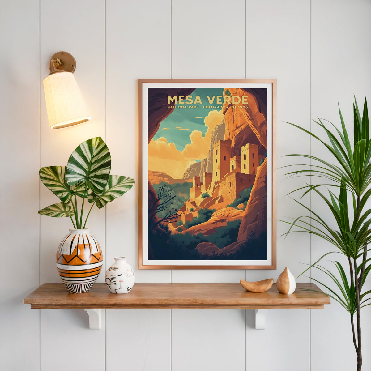 Mesa Verde National Park print in a copper frame above an oak shelf on white shiplap with a brass sconce