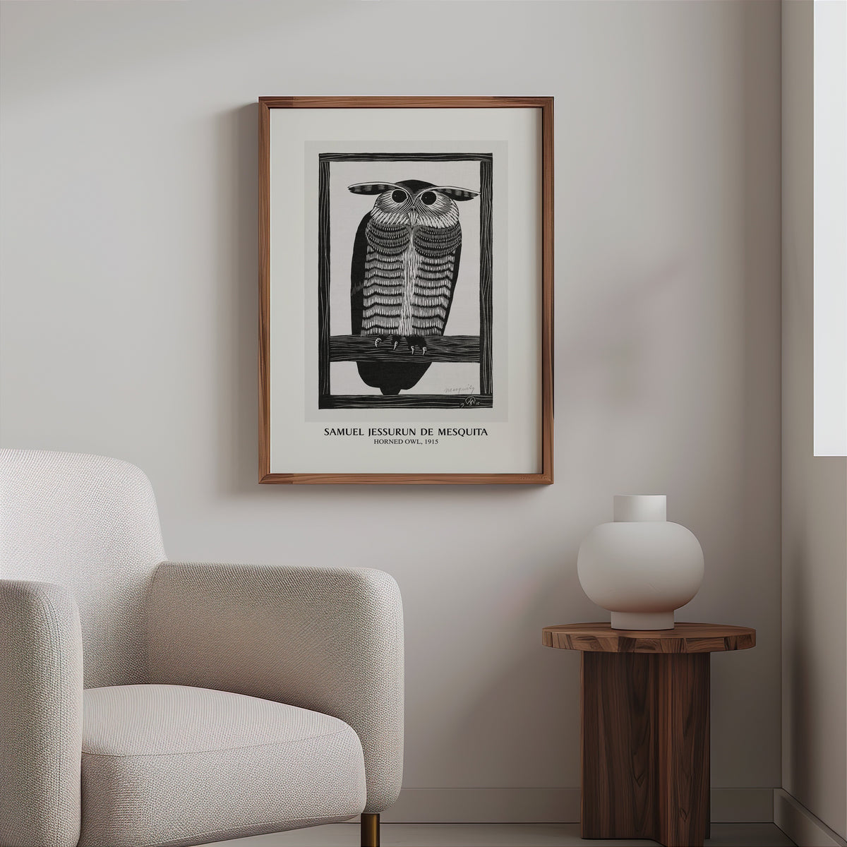 Owl woodcut print in a slim walnut frame above a bouclé armchair