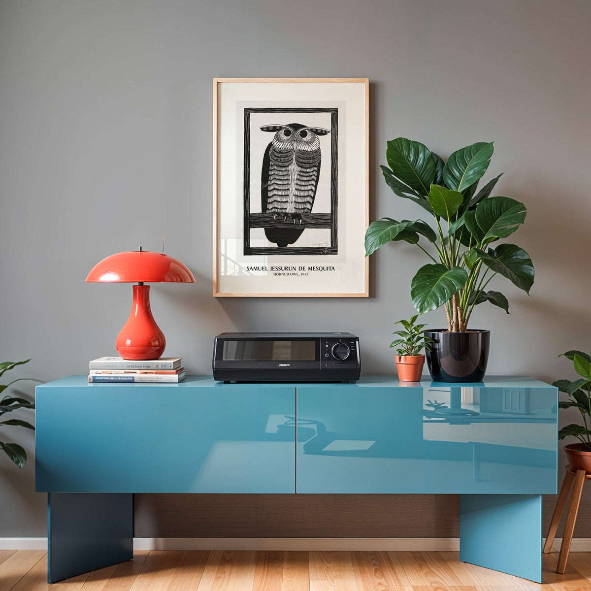 Black and white owl print in an oak frame above a teal sideboard