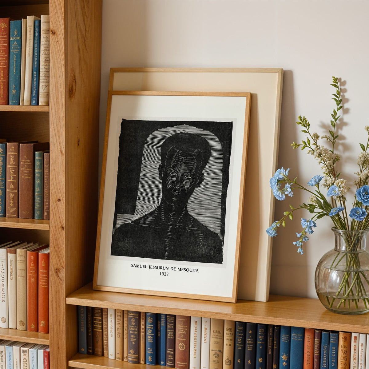 Black and white portrait in an oak frame leaning on a bookshelf beside flowers