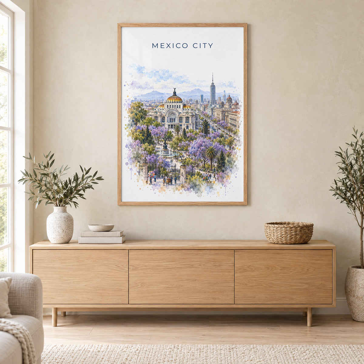 Mexico City watercolor print in an oak frame above a light wood sideboard in a Scandinavian living room