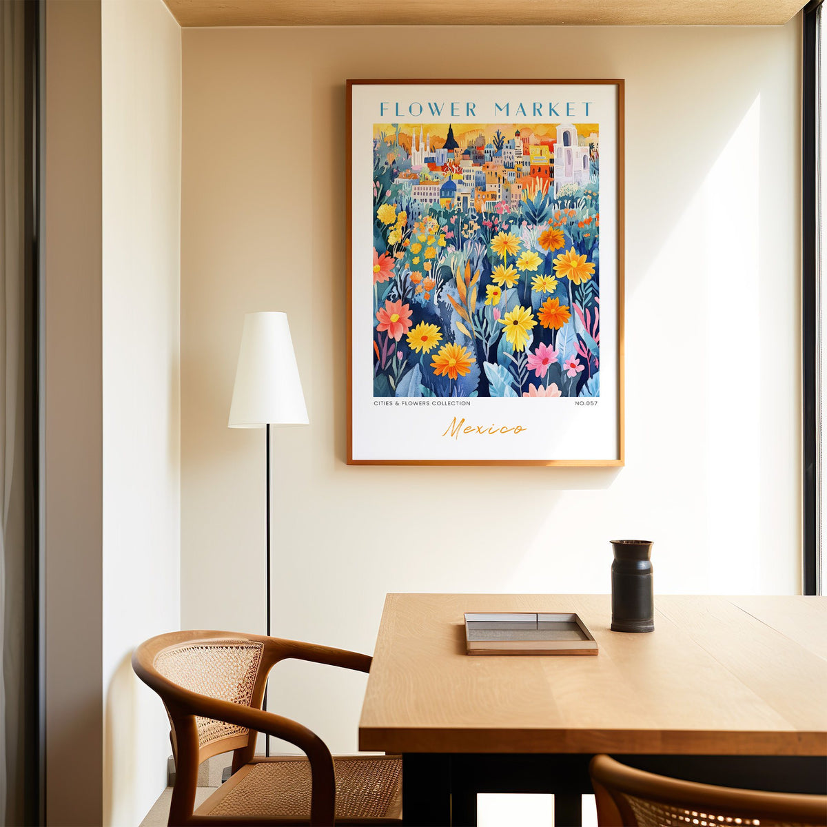 Mexico flower market print in an oak frame above a dining table and cane chair