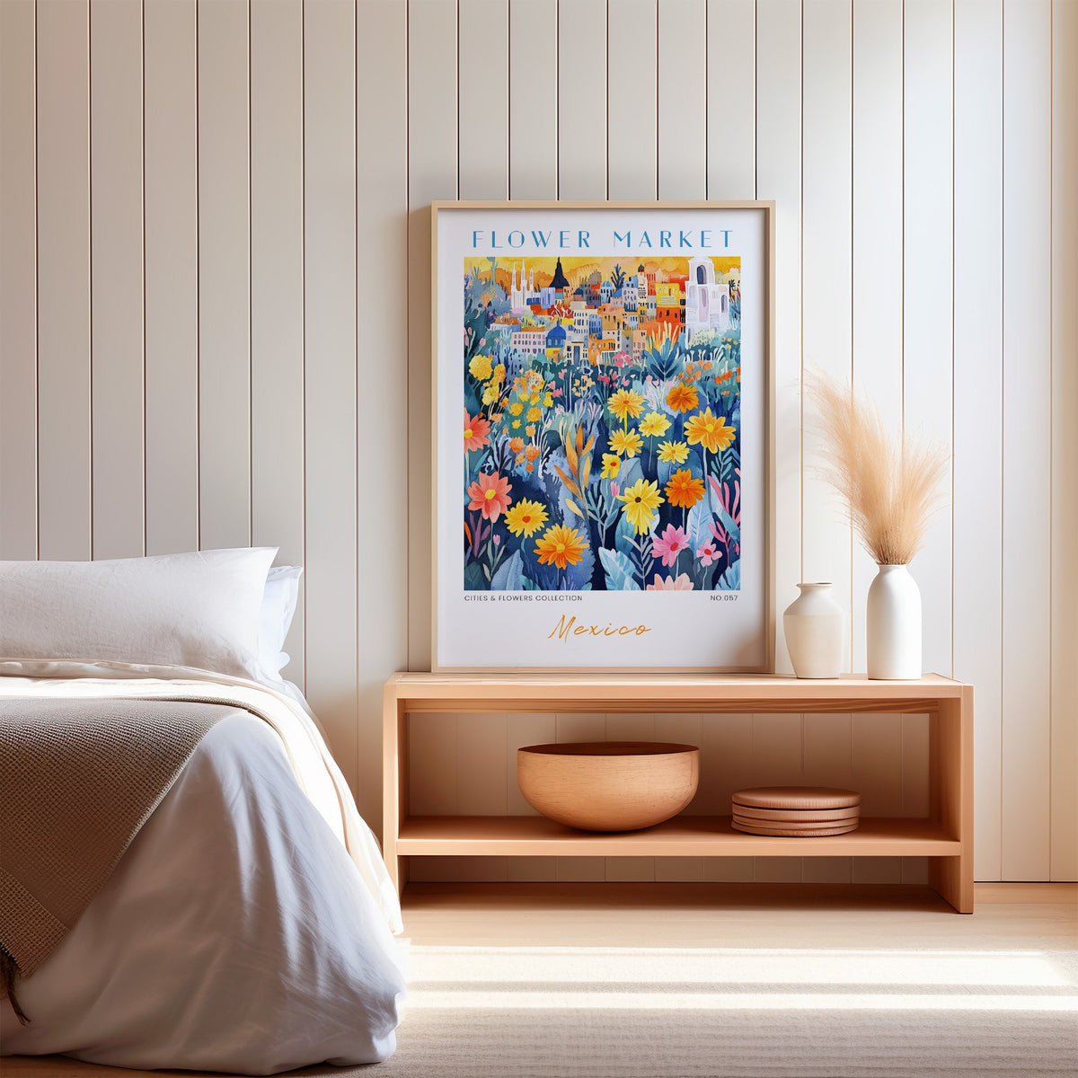 Mexico flower market print in an oak frame on a wood bench against a white shiplap bedroom wall with pampas grass