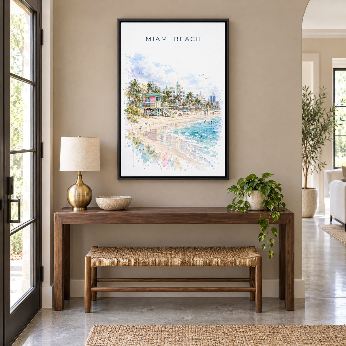 Miami Beach watercolor print as a black floater canvas above a walnut console and woven bench in an entryway