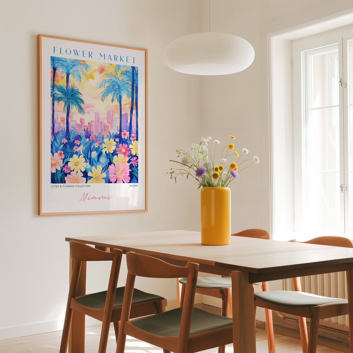 Miami flower market print in an oak frame above a dining table with a yellow vase and white pendant light