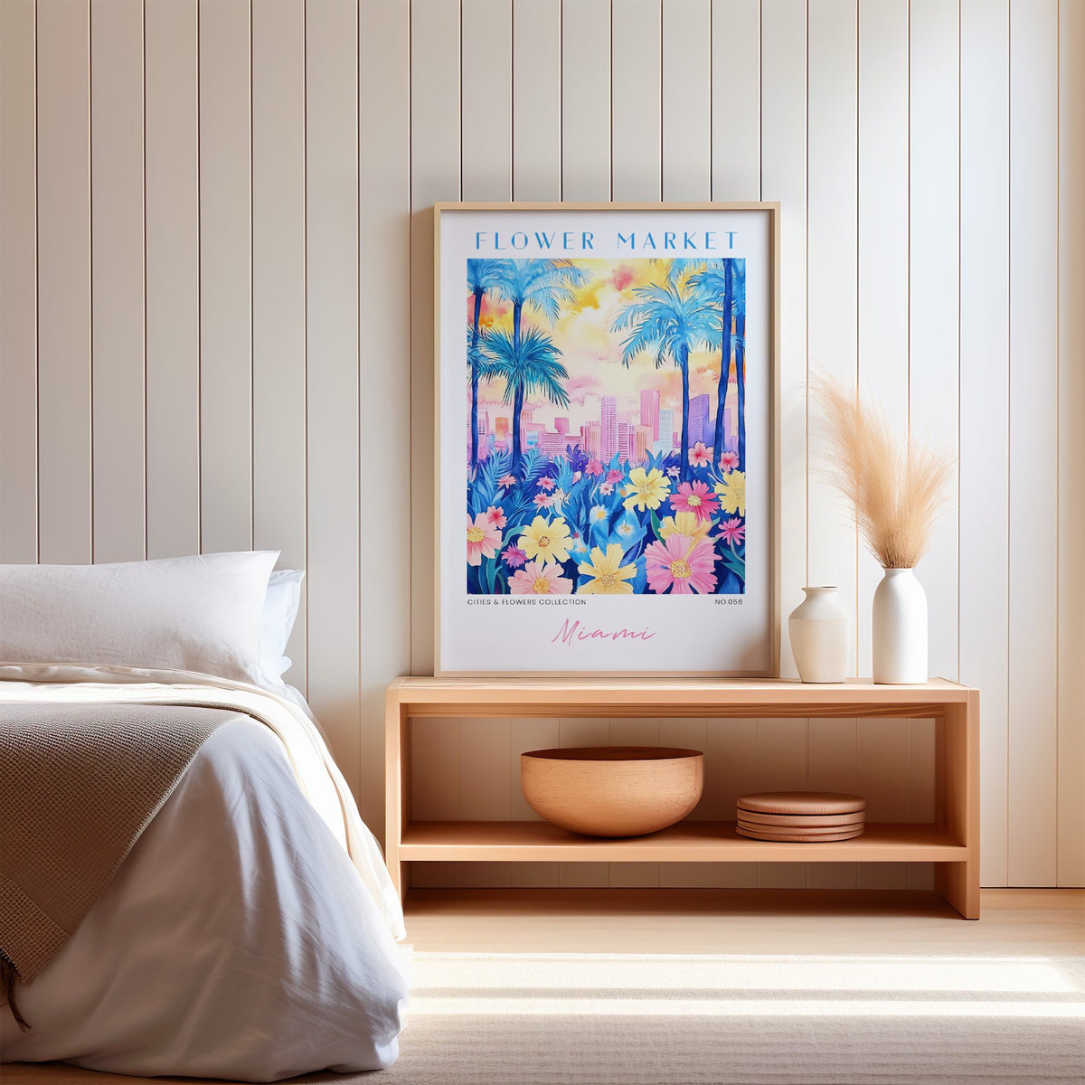 Miami flower market print in an oak frame on a wood bench against a white shiplap bedroom wall with pampas grass