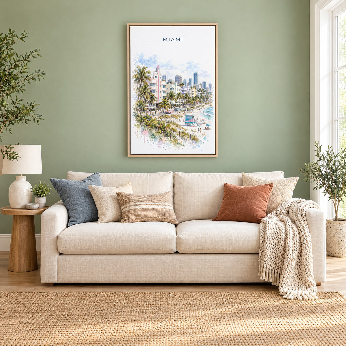 Miami watercolor print as a natural floater canvas above a cream linen sofa on a sage green wall