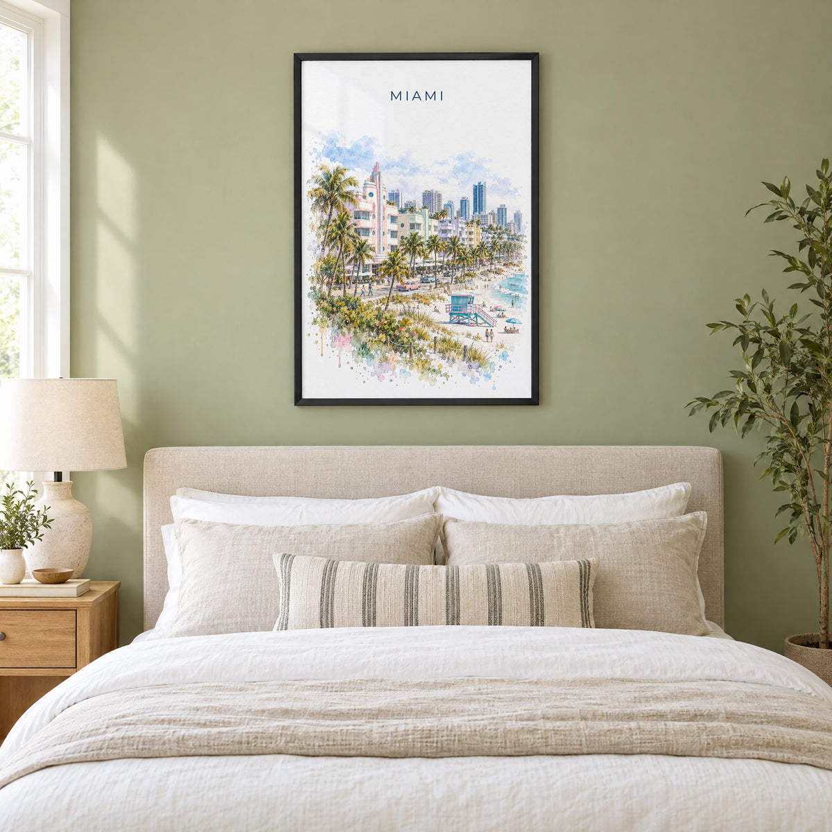 Miami watercolor print in a black frame above an upholstered headboard in a sage green bedroom