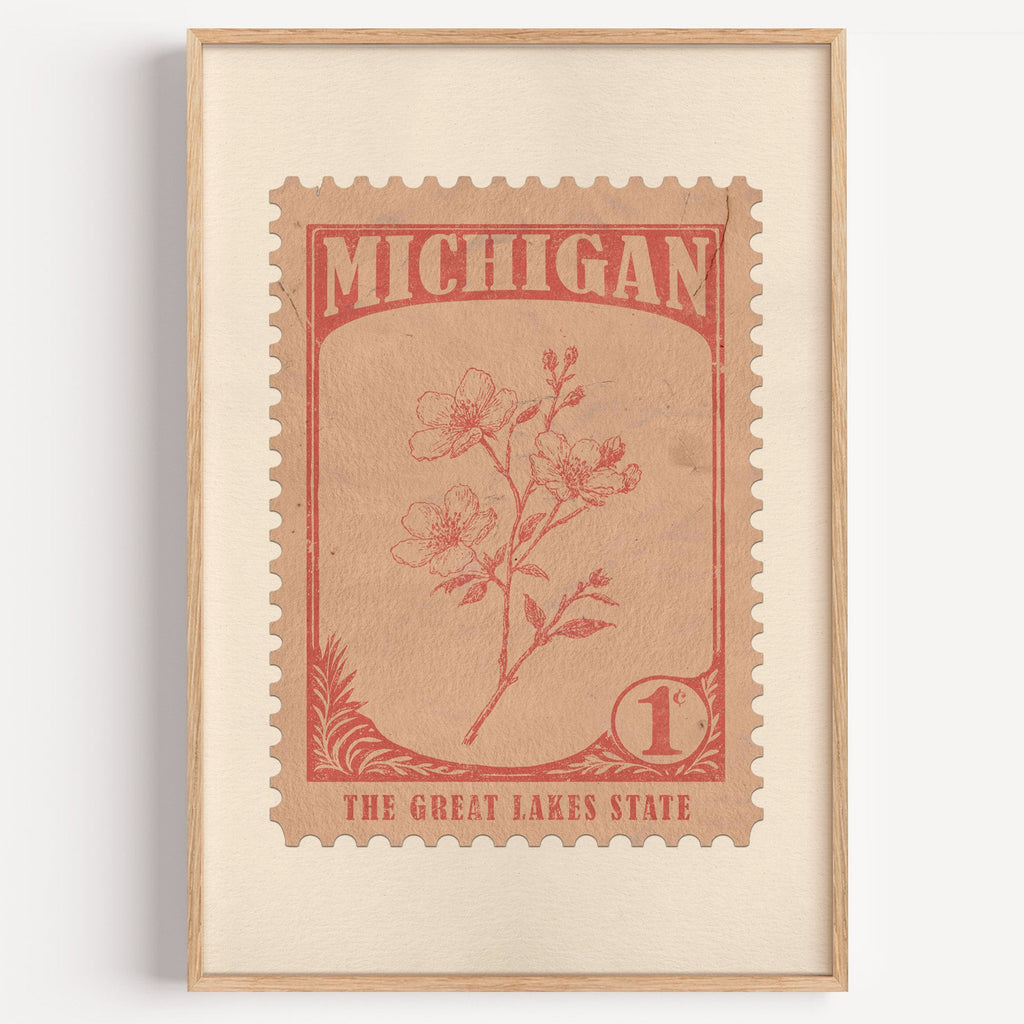 Michigan state flower stamp print in terracotta on peach, light oak frame on a plain white wall